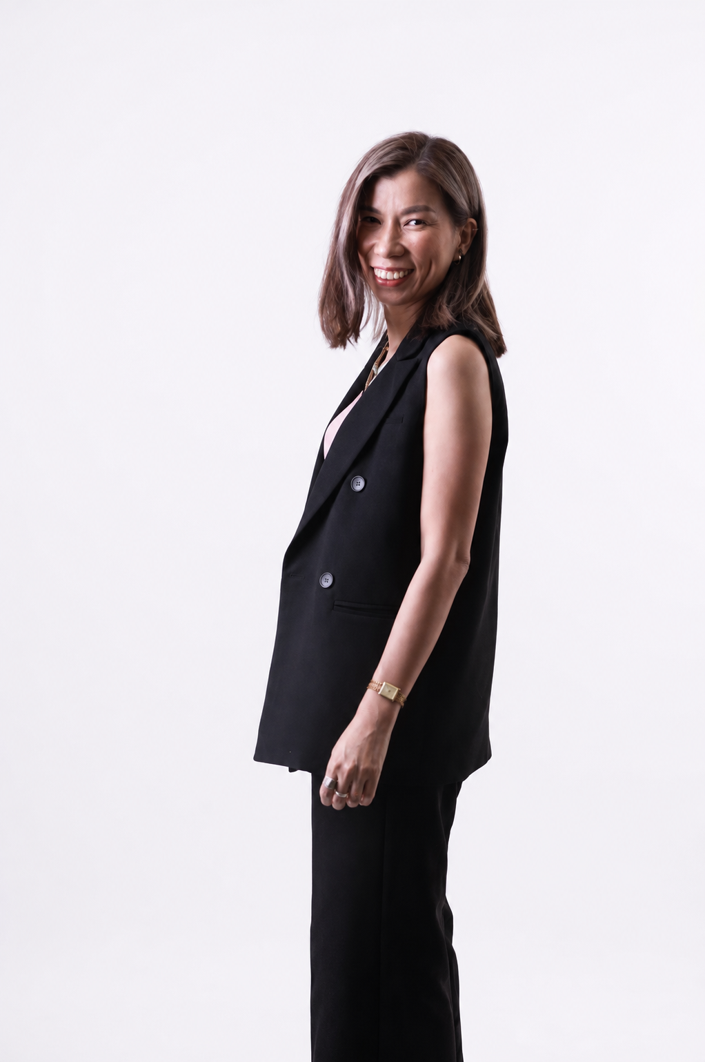 Worakamol Meepiarn smiling in a black-vest editorial portrait